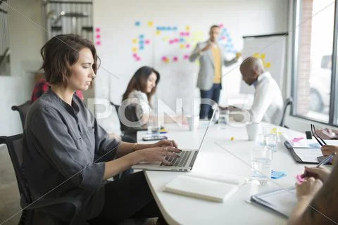 Businesswoman using laptop in office meeting Stock Photos