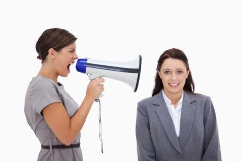 Businesswoman using megaphone to yell at colleague Stock Photos