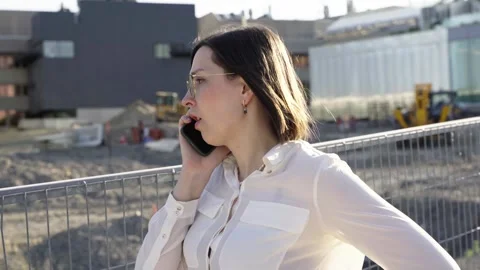 Businesswoman using smartphone while walking near construction area Stock Footage 244246451