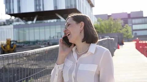 Businesswoman using smartphone while walking near construction area Stock Footage 244246465