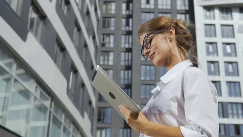 Businesswoman Using Tablet in front of Corporation Stock Footage