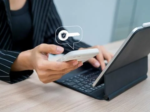 Businesswoman using two-factor authentication or 2FA via smartphone and tab.. Stock Photos