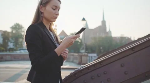 Businesswoman Waking Using SmartPhone in Sunny City. SLOW MOTION. STEADICAM Stock Footage