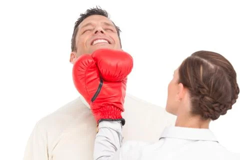 Businesswoman wearing boxing gloves punching businessman Stock Photos