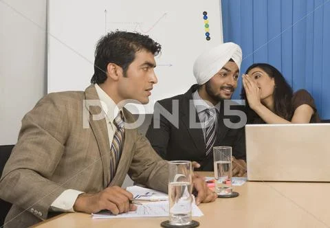 Businesswoman whispering in a board room Stock Photos