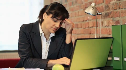 Businesswoman working on laptop having headache Stock Footage