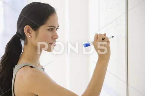 Businesswoman writing on dry erase board Stock Photos