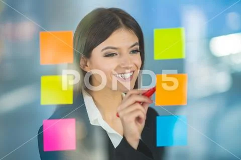 The businesswoman writing a note on the sticker Stock Photos