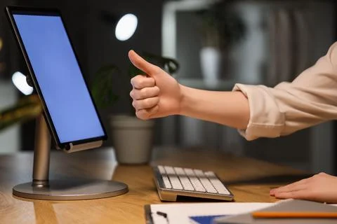 Businesswoman's hands with blank tablet computer showing thumb-up in office a Foto stock