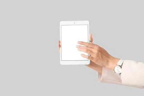 Businesswomans hands with blank tablet computer on light background Stock Photos