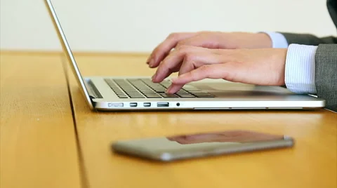 Businesswoman's hands using laptop by smart phone at desk Stock Footage 53471012