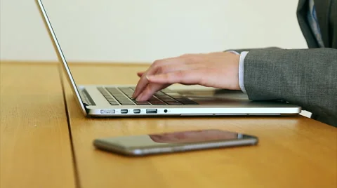 Businesswoman's hands using laptop by smart phone at desk Stock Footage 53471028