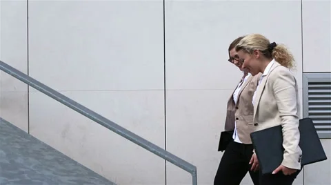 Businesswomen talking while walking up staircase Stock Footage 28993520