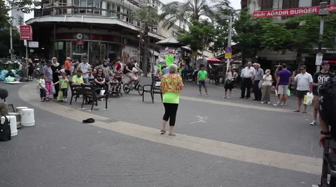 Busker drummer drums on buckets and pots, woman dances in Tel-Aviv Stock Footage 53232502