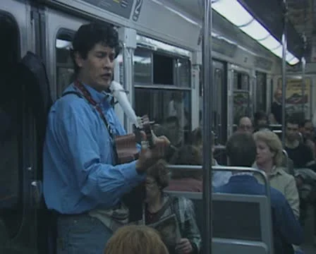 Busker inside subway train playing music and singing Stock Footage 8916210