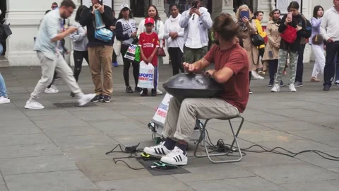 Busker playing hand drum music on London street in front of people around Video stock 142159434