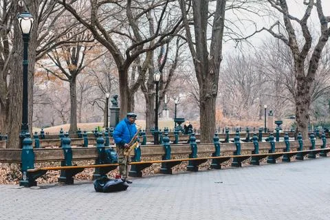 Busker playing saxophone while other passersby pass around him, Central Par.. Stock-Fotos