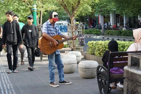 The busker is singing with the guitar Stock Photos