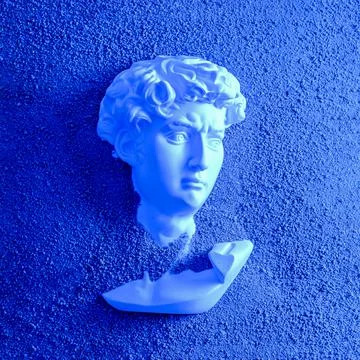Bust head of David plaster antique in the sand on the beach. Stock Photos