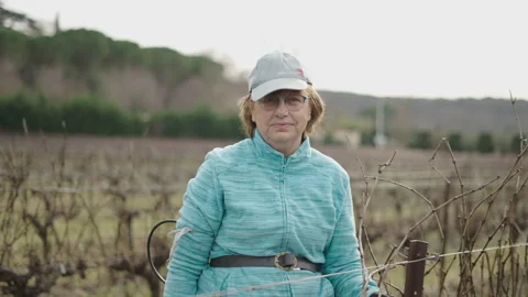 Bust senior woman smiling and waving while pruning vines with an electric Stock-Footage 276835341