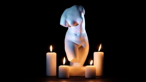 Bust of Venus and burning candles on a black background Stock Footage 101419289