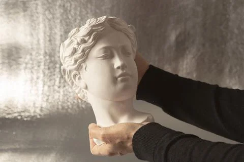 Bust of a white statue held by a hands Stock Photos