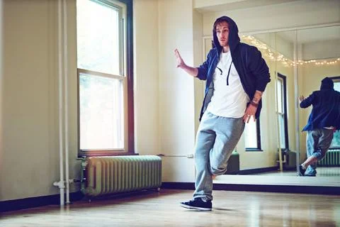 Busting out those breakdance moves. a young man breakdancing in a studio. Stock Photos