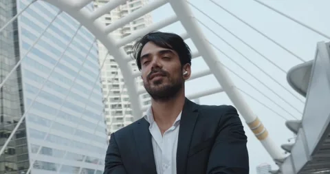 Bustling city center middle eastern man sharp business suit headphones stands Stock Footage 312500591