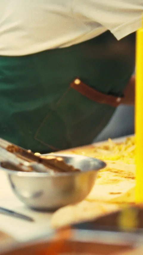 In a bustling fast-food kitchen a skilled chef expertly prepares shawarma as Stock Footage 334397148