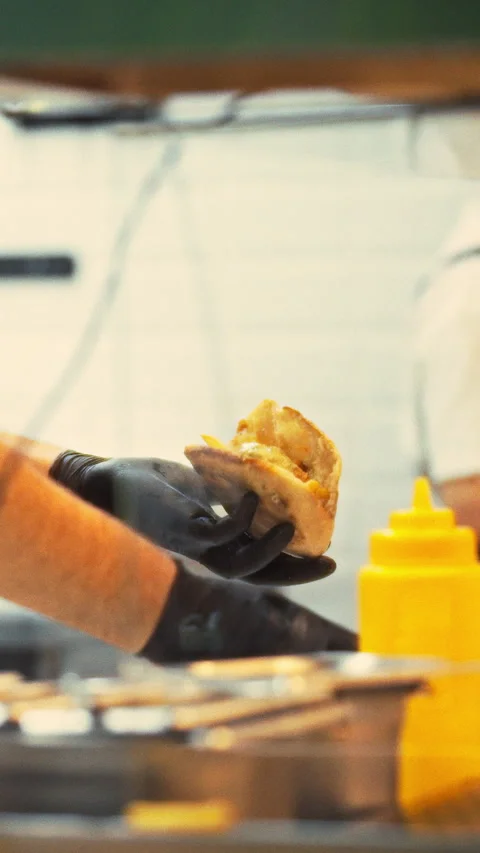 In bustling kitchen team of workers expertly prepare and serve hamburgers to Stock Footage 334394788