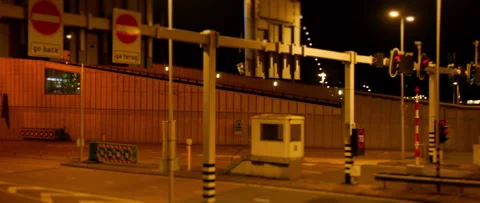 A bustling nighttime urban scene featuring traffic signals and a security booth Stock Footage 302361519