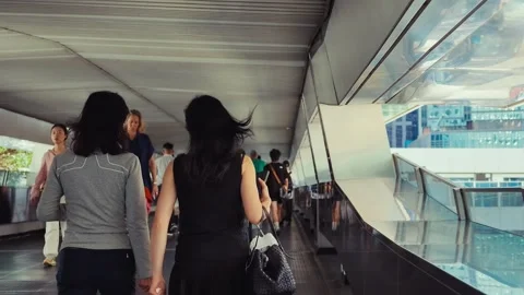 A bustling pedestrian bridge in modern, high-tech Hong Kong, featuring sleek 库存影片 338311434