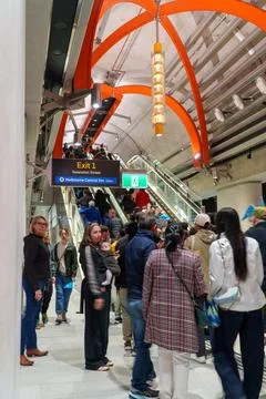 A bustling scene with people using escalators and walking through the moder.. Stock Photos