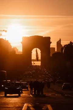 Bustling street with the Arc de Triomphe in the sunset background, Paris Stock Photos
