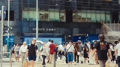 A bustling street in front of a modern building with 'Citi Bank' signage. Video stock 338311490