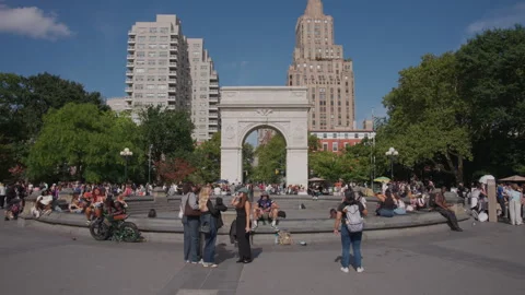 Bustling street scene at Washington Square Park in New York City, with visitors Stock Footage 347137977