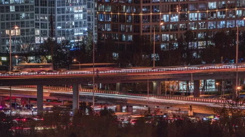 The bustling urban traffic flows through the city at night in a prosperous metro Stock Footage 296995494