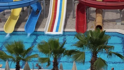 In bustling water park vibrant multi-colored water slide stands out promising Vidéo 277182587