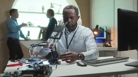 Busy African American developer building robotic hand in laboratory. Hardworking Stock Footage 241241575