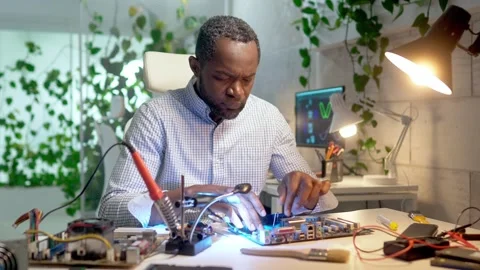 Busy African American developer engineering electronic device. Serious man Stock Footage 241260177