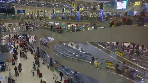 Busy airport terminal with multiple escalators and travelers in motion blur. Stock Footage 337904288