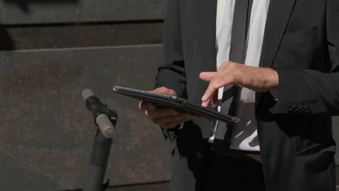 Busy businessman checking files on tablet computer outdoor Stock Footage 143906442