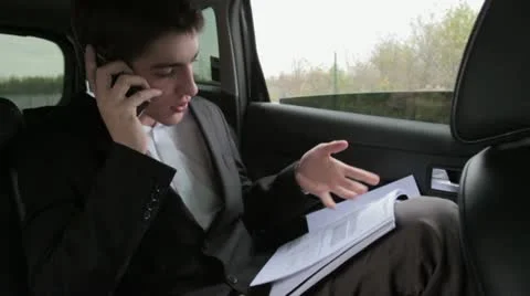 Busy businessman with documents and mobile phone in car HD Stock Footage