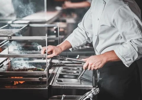 Busy chef at work in the restaurant kitchen Stock Photos