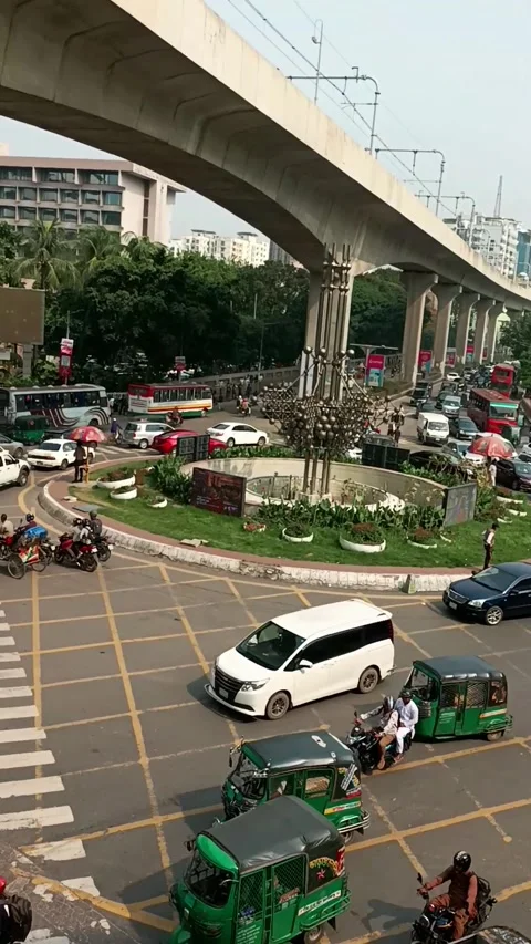 Busy city intersection traffic flowing under elevated metro rail tracks Stock Footage 335221907