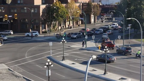 Busy city intersection in Victoria BC with cars, cyclists, and pedestrians Stock Footage