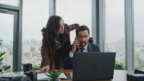 Busy colleagues solving problems on phone conversation at office. Couple working Foto stock