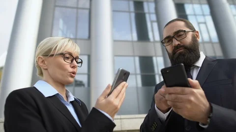 Busy colleagues using mobile business app on smartphones, modern technology Vídeo Stock 117378083