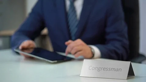 Busy congressman working on tablet pc, reading political news in online media Stock Footage 71593196