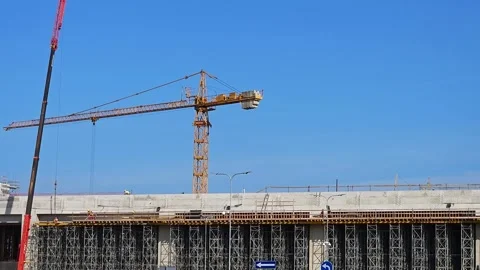 A busy construction building with workers walking across concrete sections Stock Footage 286081156
